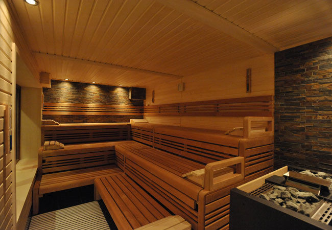 Professionelle Design-Sauna mit beleuchteter Natursteinwand. corso sauna manufaktur gmbh Sauna Wood Wood effect
