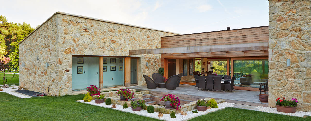 Una Casa con Paredes de Piedra y Jardines de Sueño, HUGA ARQUITECTOS HUGA ARQUITECTOS Rustic style house Cielo,Planta,Edificio,Propiedad,Nube,casa,Árbol,Lote de tierra,Flor,Césped